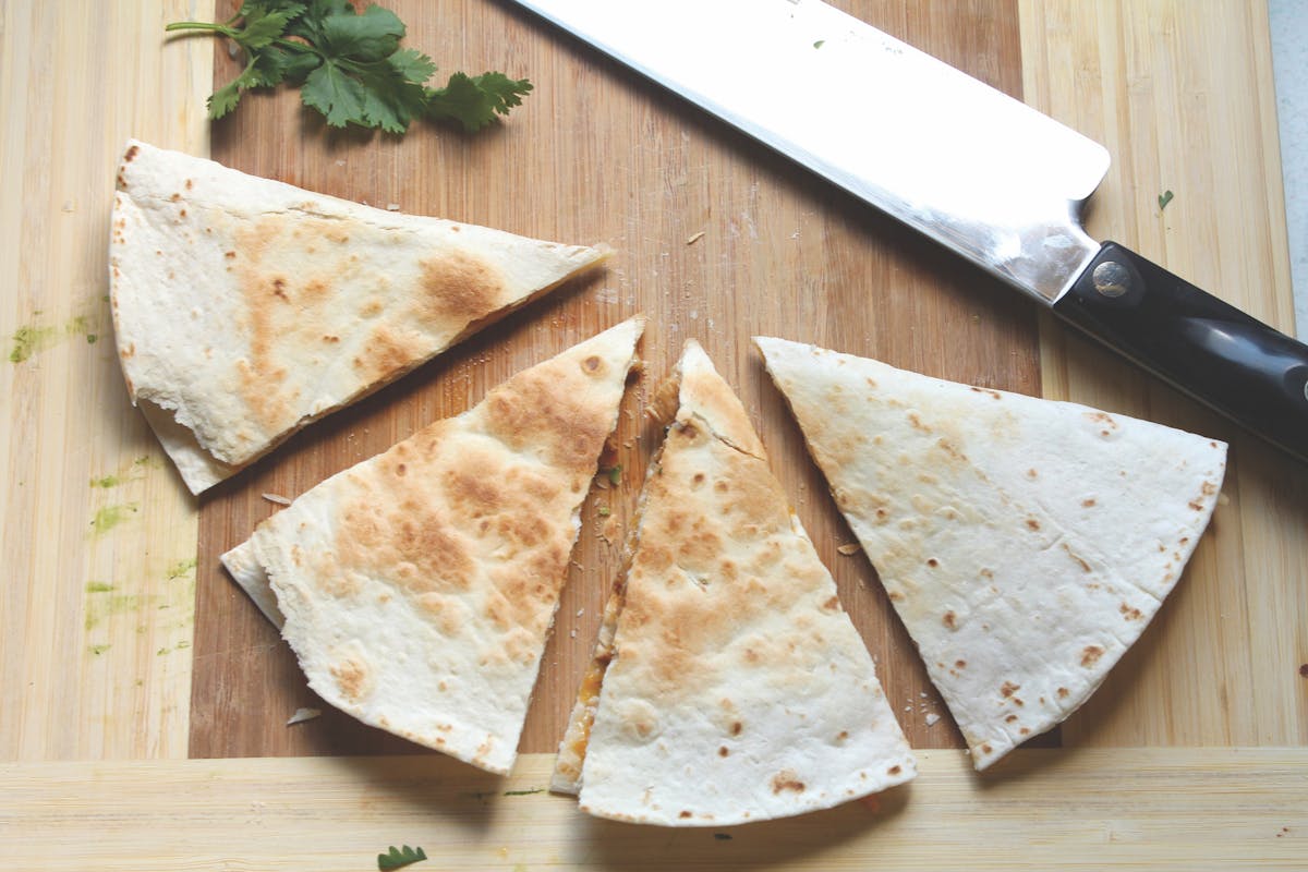 a cut in half sandwich sitting on top of a wooden cutting board